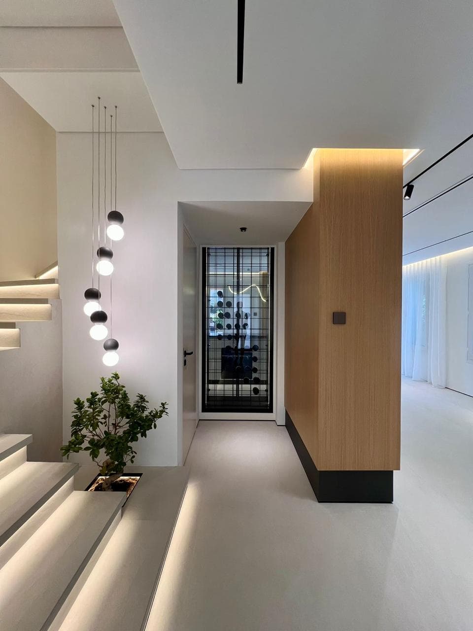 Luxury apartment hallway with wood-slat wall, pendant lights and integrated wine cellar — Concreto interior fit-out